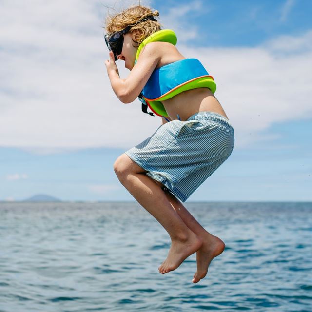 Kid jumping into the ocean